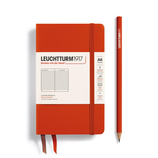 A fox red hardcover notebook with an elastic to keep it closed.